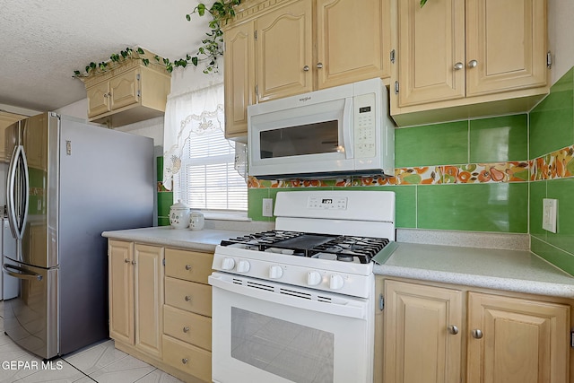 kitchen featuring backsplash, white appliances, light tile patterned floors, and a textured ceiling