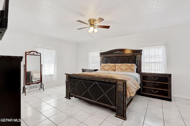 bedroom featuring ceiling fan, a textured ceiling, and light tile patterned flooring