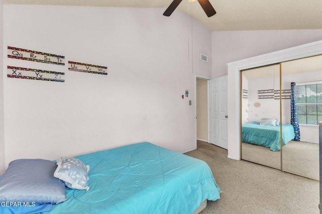 bedroom with carpet floors, vaulted ceiling, a closet, and ceiling fan