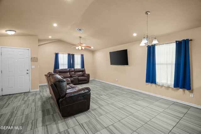 living room with ceiling fan with notable chandelier and vaulted ceiling