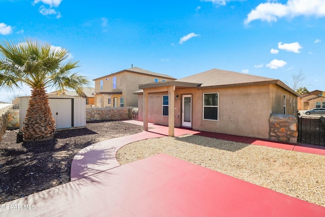 rear view of property featuring a shed and a patio area