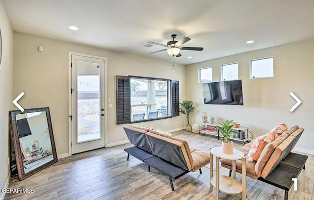 living room featuring ceiling fan and light hardwood / wood-style flooring