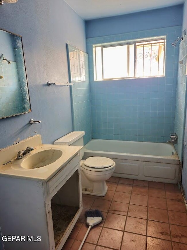 full bathroom featuring vanity, toilet, tiled shower / bath combo, and tile patterned flooring