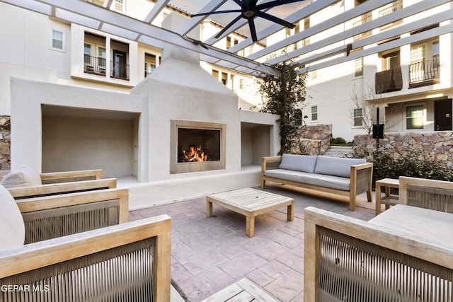 exterior space with an outdoor living space with a fireplace and a pergola