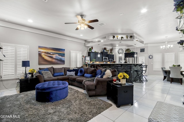 tiled living room with ceiling fan with notable chandelier