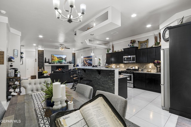 tiled dining space with ceiling fan with notable chandelier