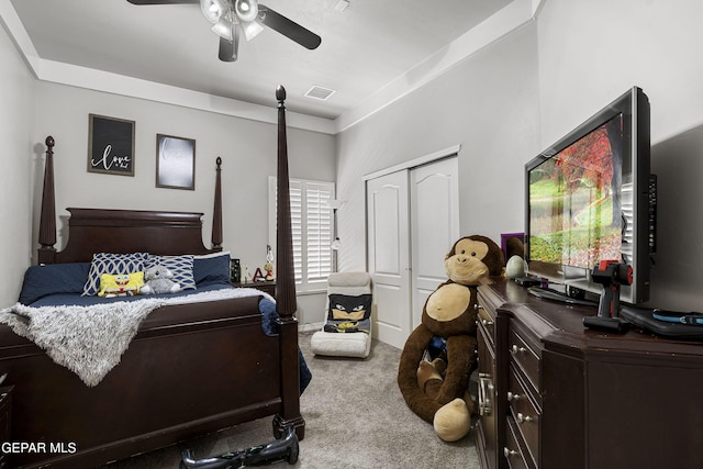 carpeted bedroom with ceiling fan and a closet