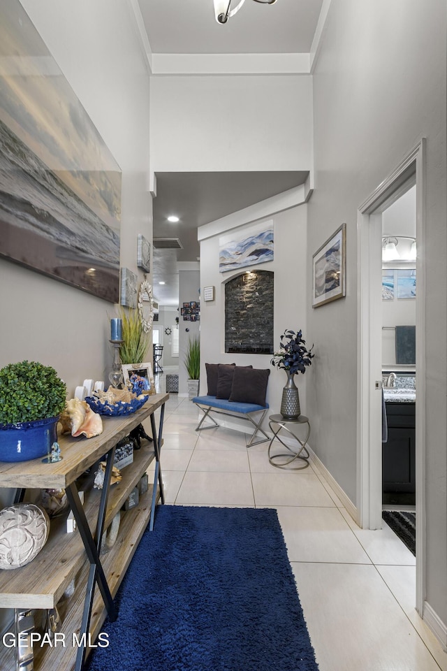 tiled foyer featuring crown molding and sink