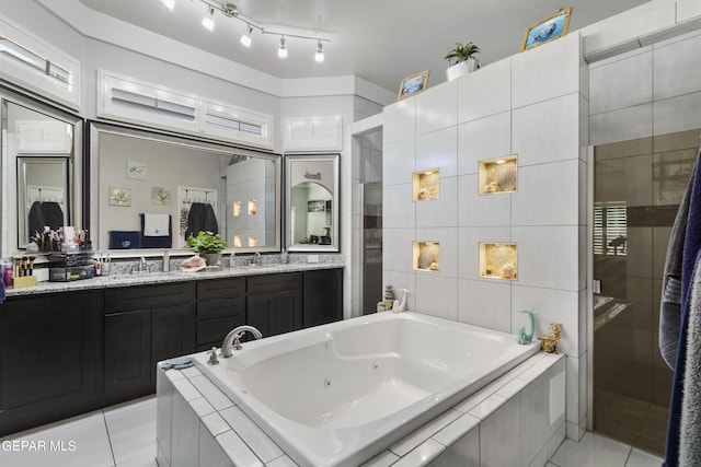 bathroom with vanity, independent shower and bath, tile patterned flooring, and tile walls