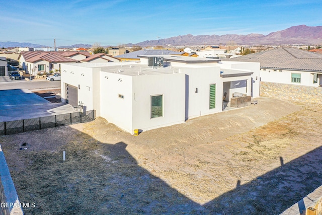 rear view of property featuring a garage and a mountain view