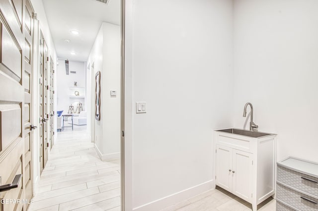 hallway featuring sink and light wood-type flooring