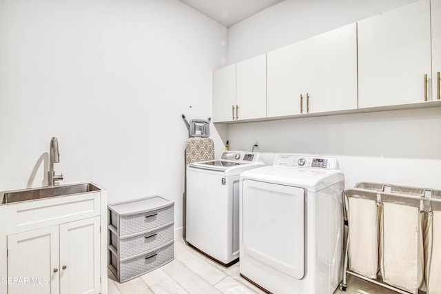 laundry area with cabinets, separate washer and dryer, and sink