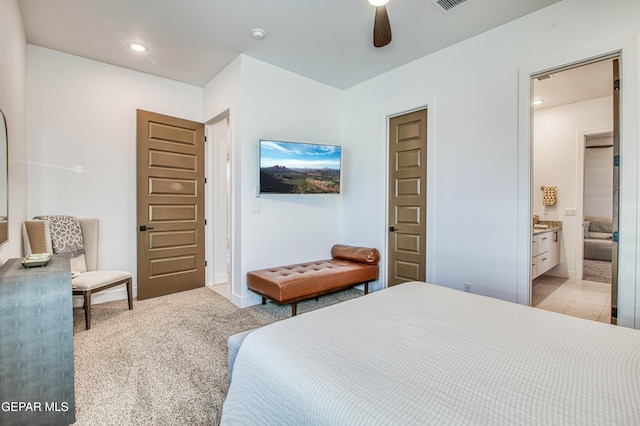 carpeted bedroom featuring ceiling fan and ensuite bathroom