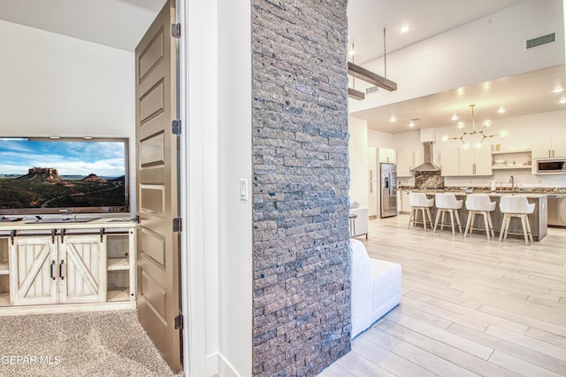 interior space with an inviting chandelier, sink, and light hardwood / wood-style flooring