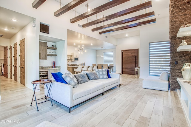 living room with beamed ceiling, a high ceiling, a notable chandelier, and beverage cooler