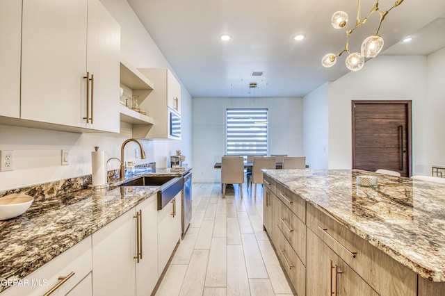 kitchen with light stone countertops, sink, and light hardwood / wood-style flooring