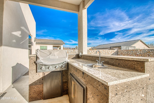 view of patio featuring exterior kitchen, sink, and grilling area