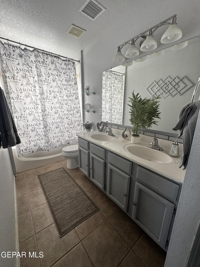 full bathroom featuring a textured ceiling, vanity, toilet, shower / bathtub combination with curtain, and tile patterned floors