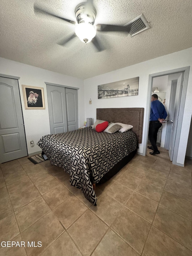 bedroom with tile patterned flooring, a closet, and a textured ceiling