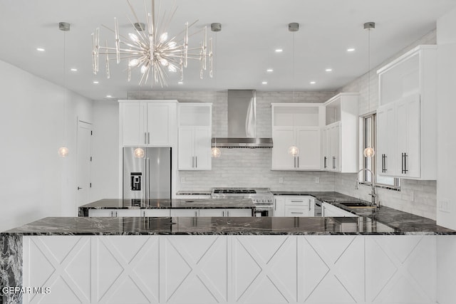 kitchen with pendant lighting, sink, wall chimney exhaust hood, and appliances with stainless steel finishes