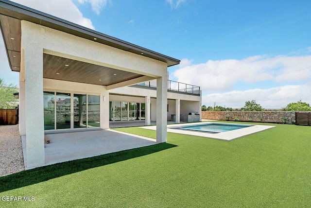 back of property featuring a fenced in pool, a lawn, and a patio area