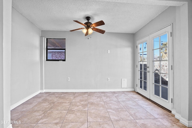 unfurnished room with a textured ceiling, ceiling fan, and light tile patterned flooring