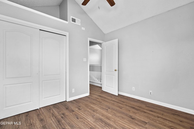 unfurnished bedroom featuring ceiling fan, lofted ceiling, dark hardwood / wood-style floors, and a closet