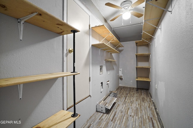 interior space with hookup for a washing machine, light hardwood / wood-style floors, and ceiling fan