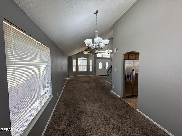 interior space featuring an inviting chandelier, carpet floors, high vaulted ceiling, and a textured ceiling