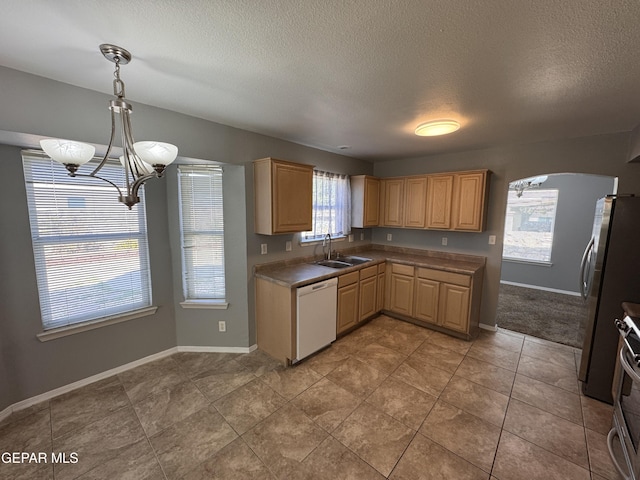 kitchen with sink, stainless steel fridge, dishwasher, decorative light fixtures, and light brown cabinets