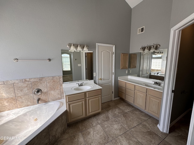 bathroom featuring vanity, a wealth of natural light, tile patterned floors, and high vaulted ceiling