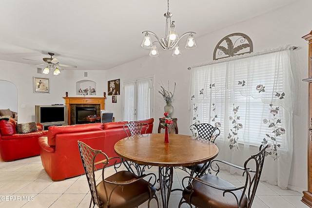 dining area featuring light tile patterned flooring, ceiling fan with notable chandelier, and french doors