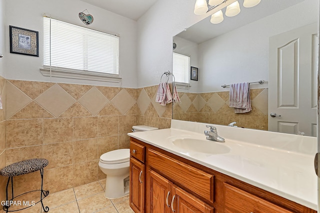 bathroom with tile walls, vanity, tile patterned floors, and a healthy amount of sunlight