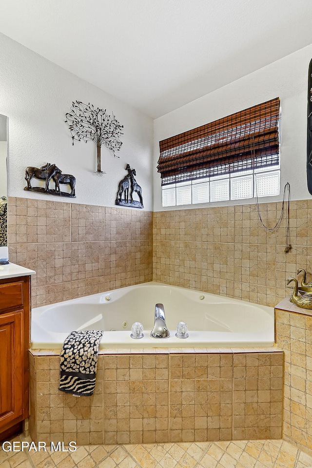 bathroom featuring tiled tub and vanity