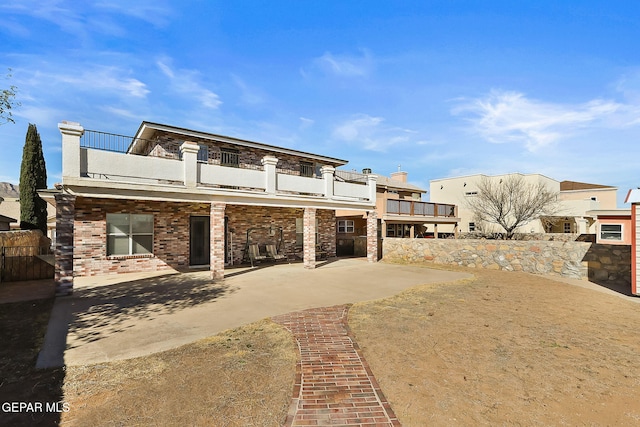 view of front of house with a balcony and a patio area