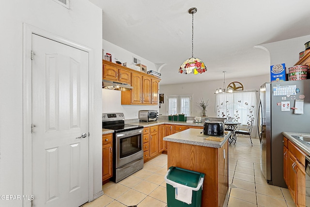 kitchen featuring stainless steel appliances, a kitchen island, light tile patterned floors, and decorative light fixtures