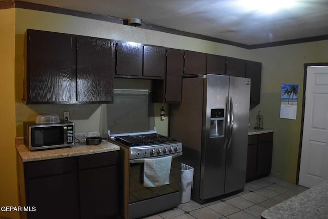 kitchen with light tile patterned floors, dark brown cabinets, and stainless steel appliances