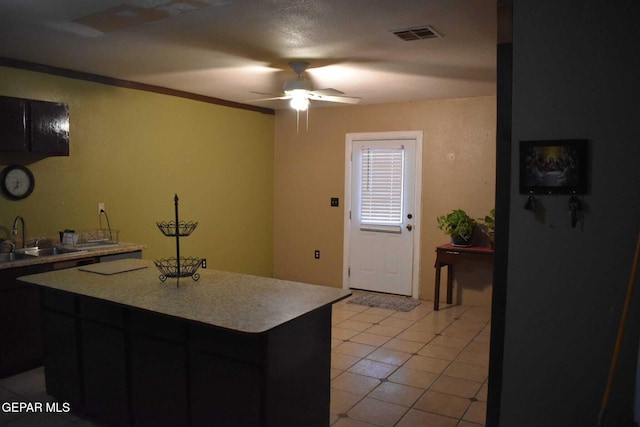 kitchen featuring crown molding, ceiling fan, sink, and light tile patterned floors