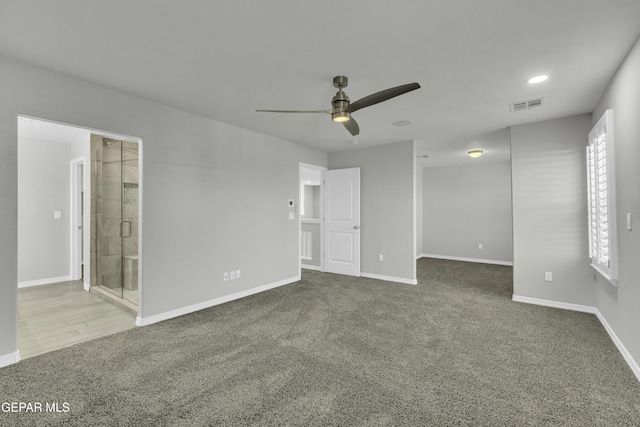 interior space featuring a walk in closet, carpet floors, connected bathroom, and ceiling fan