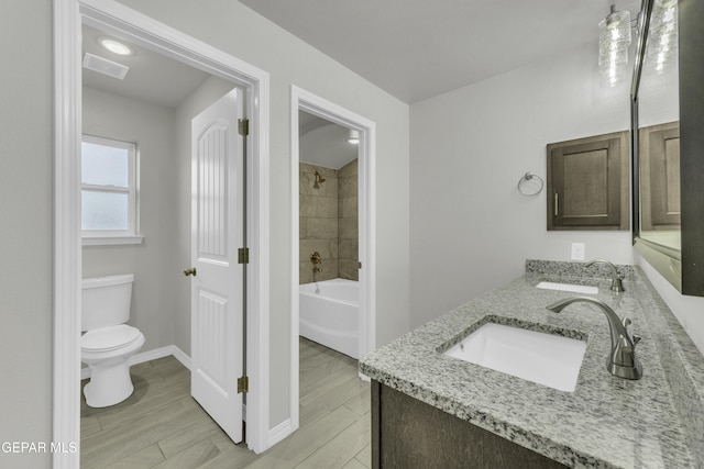 full bathroom with vanity, tiled shower / bath combo, wood-type flooring, and toilet