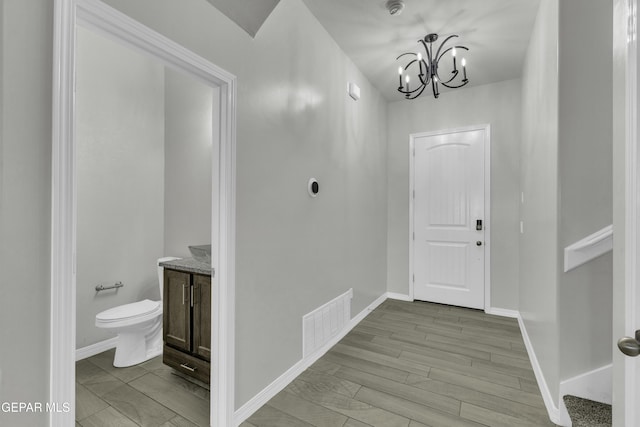 foyer with an inviting chandelier and light wood-type flooring