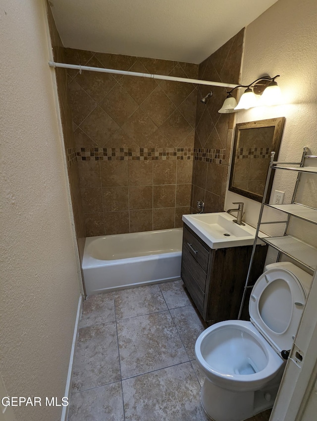 full bathroom featuring vanity, toilet, tile patterned floors, and tiled shower / bath