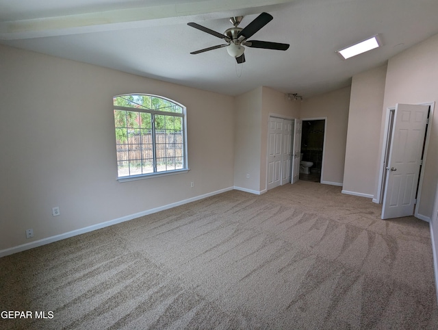 empty room with lofted ceiling, light colored carpet, and ceiling fan