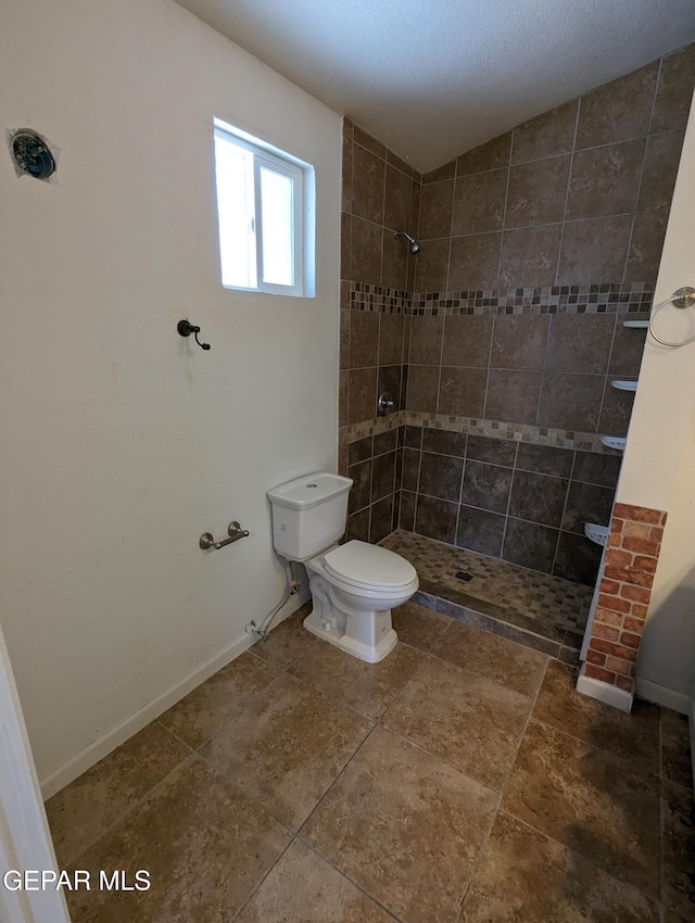 bathroom with tiled shower and toilet