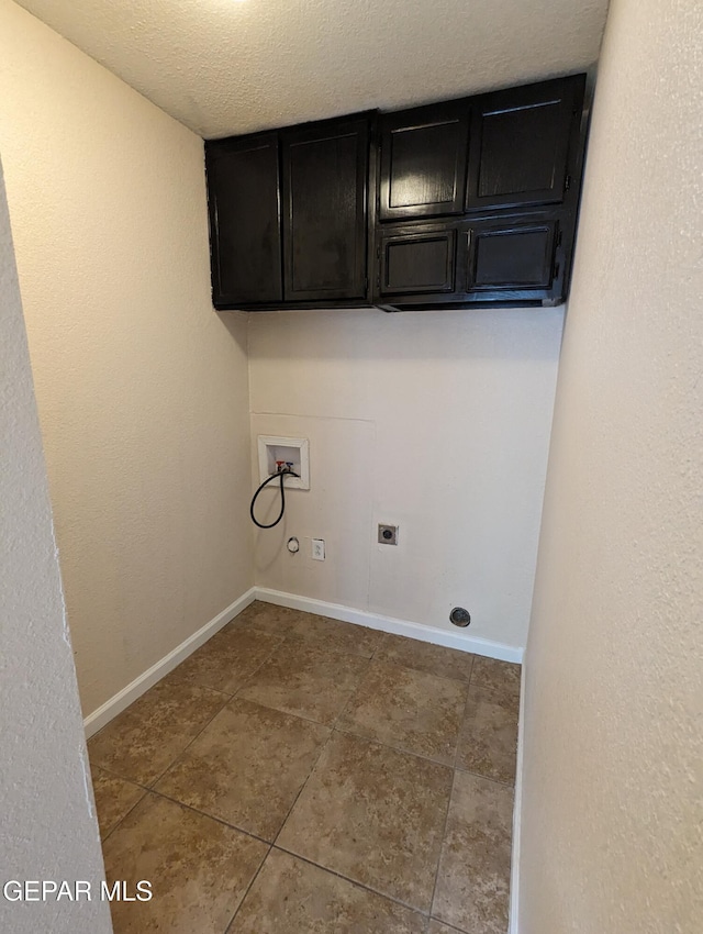 laundry area with electric dryer hookup, cabinets, washer hookup, a textured ceiling, and tile patterned floors