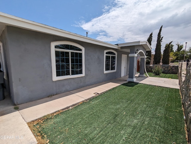 exterior space with a patio area and a front lawn