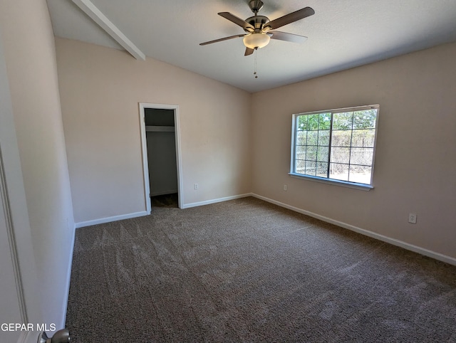 carpeted spare room featuring vaulted ceiling and ceiling fan