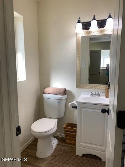 bathroom featuring vanity, hardwood / wood-style floors, and toilet