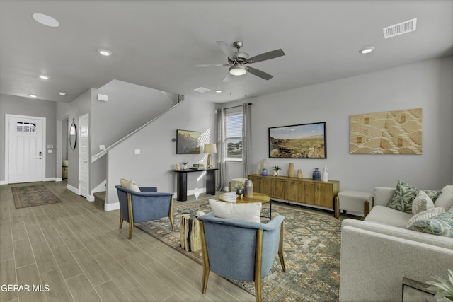 living room with light hardwood / wood-style flooring and ceiling fan