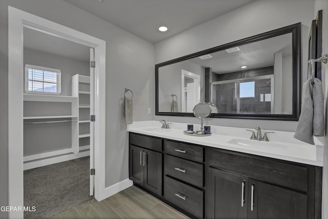 bathroom with vanity and a shower with door